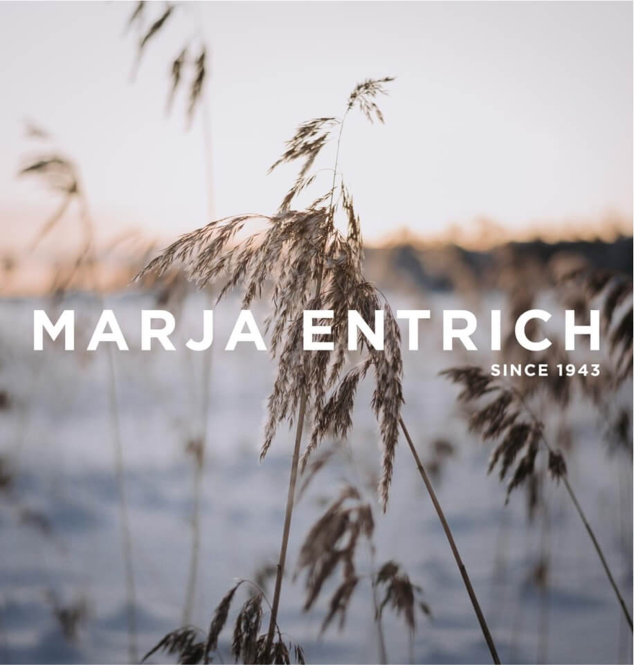Marja Entrich -logo talvisen viljakuvan päällä